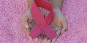 Woman holding pink breast cancer awareness ribbon
