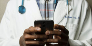 Male Doctor using a mobile phone for telehealth services