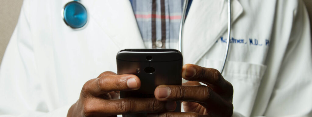 Male Doctor using a mobile phone for telehealth services